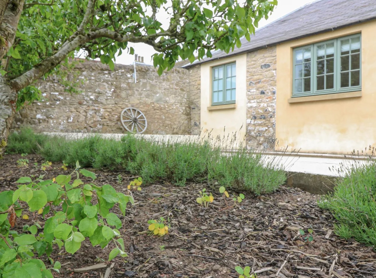 Traditional Welsh stone cottage with slate roof nestled in lush green fields